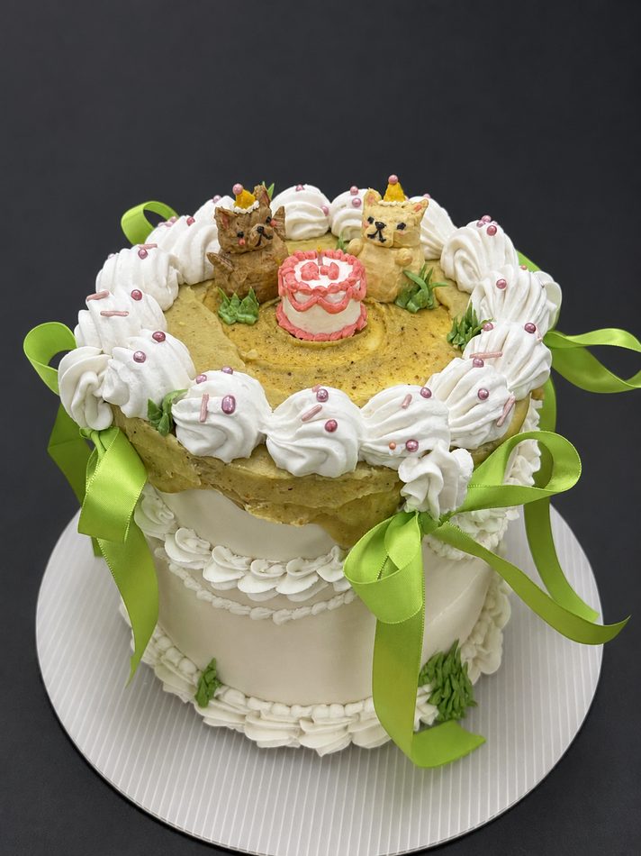 Whimsical cake with puppy toppers and a tiny cake on top