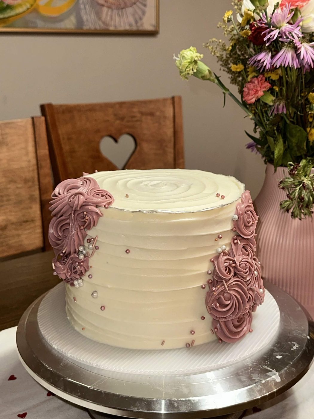 White buttercream cake with mauve rosettes and pearl sprinkles