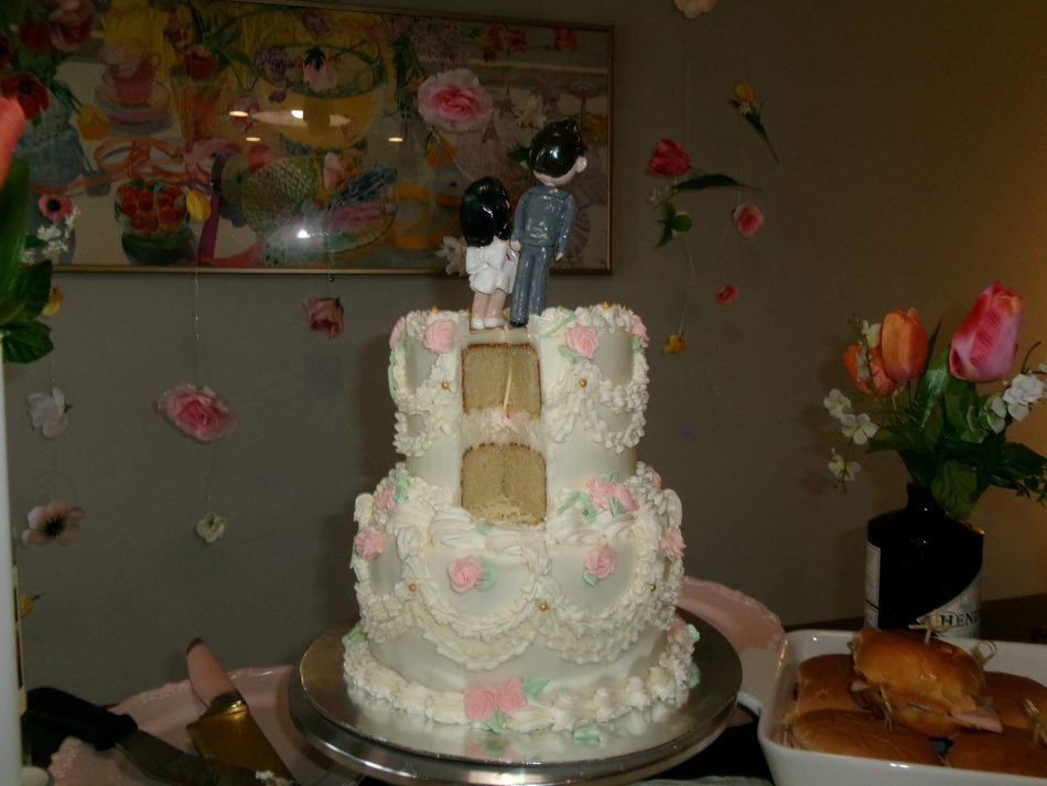 Two-tier wedding cake with bride and groom topper