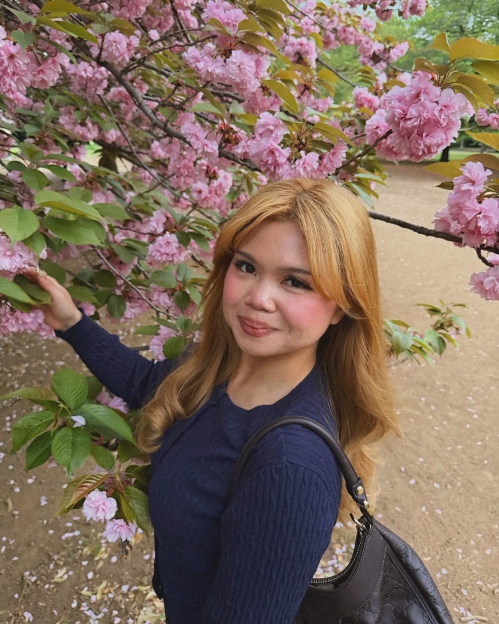 Vyonah, founder and head pastry artist, beneath cherry blossoms
